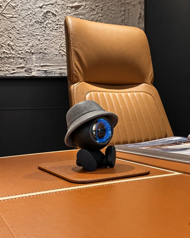 NORAA on a leather desk in front of a tan chair — prototype photograph