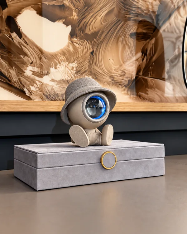 NORAA Home Edition, Ivory Stone — seated figure on a grey box, prototype photograph